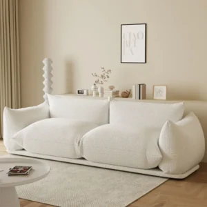Kaasaegne elutuba koos valge diivaniga, vaibaga, abilauaga ja seinal minimalistliku kunstiga.